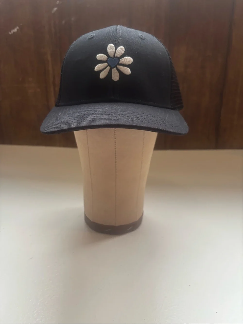 Life is Good black trucker hat daisy embroidery with a blue heart